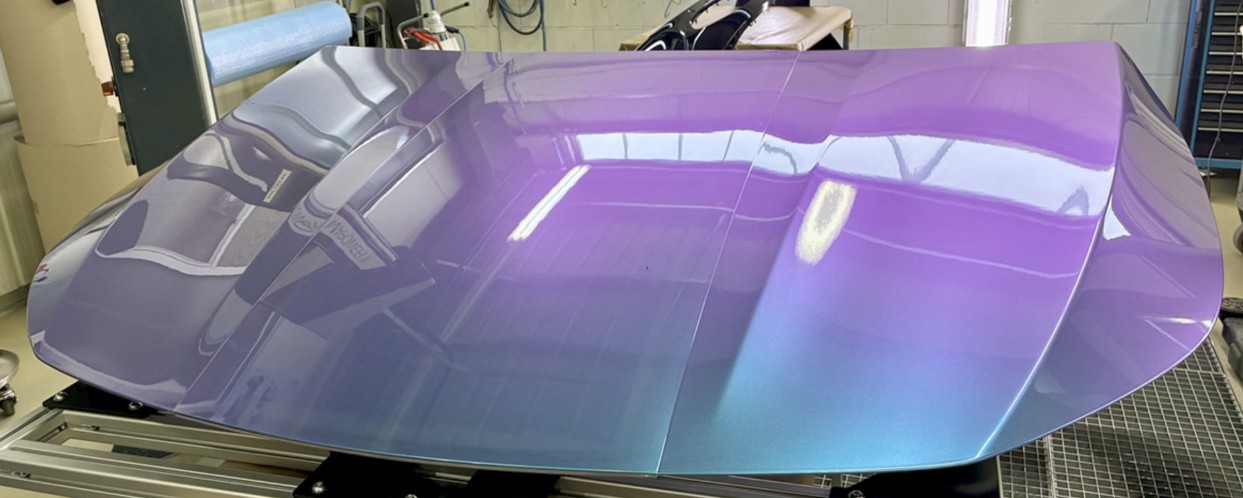 Hood prototype with a colour-shift finish on a test fixture in a workshop